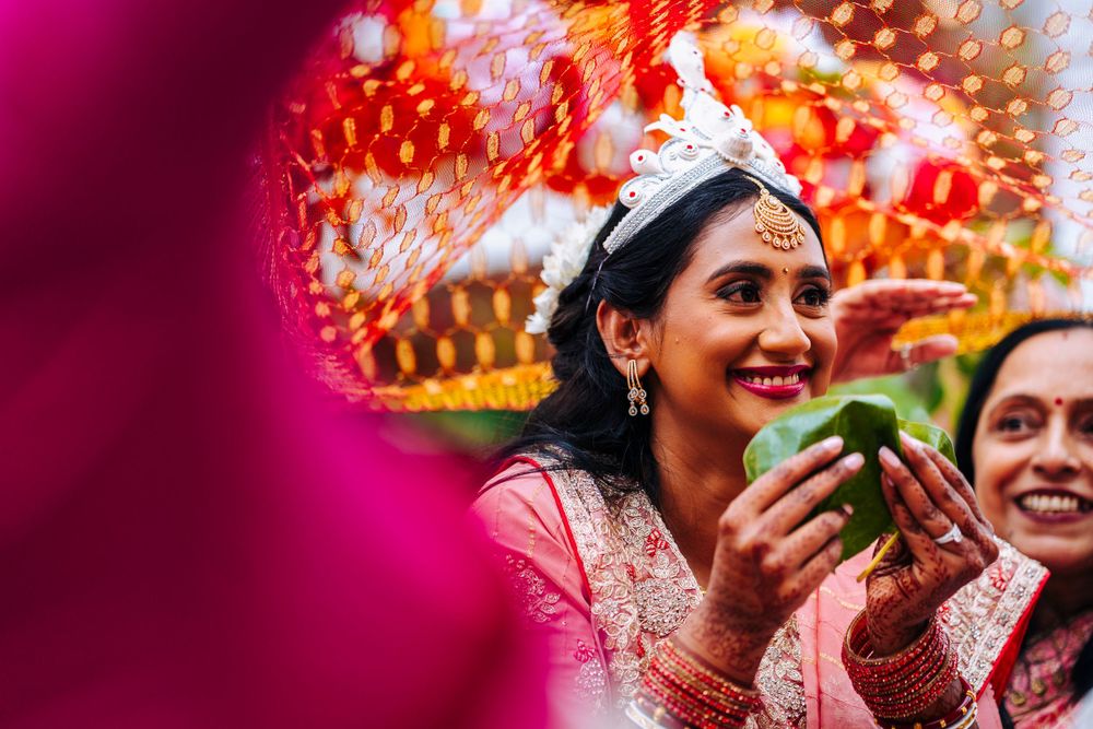 Indian bride hiding behind leaves in traditional indian ceremony in sefton park palm house