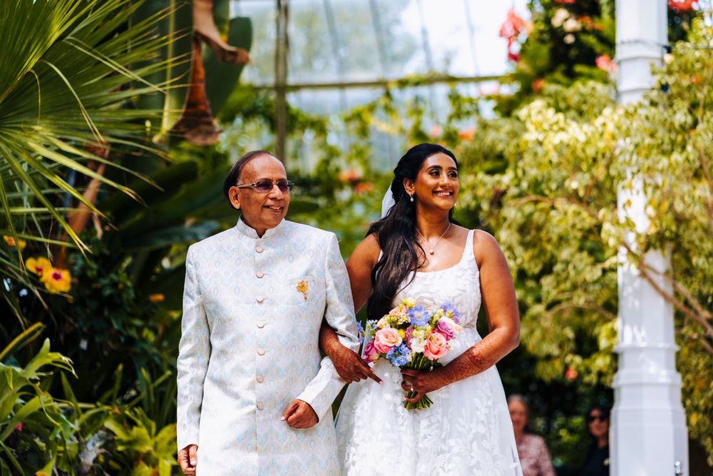 Bride being walked into wedding ceremony by dad at Sefton Park Palm House