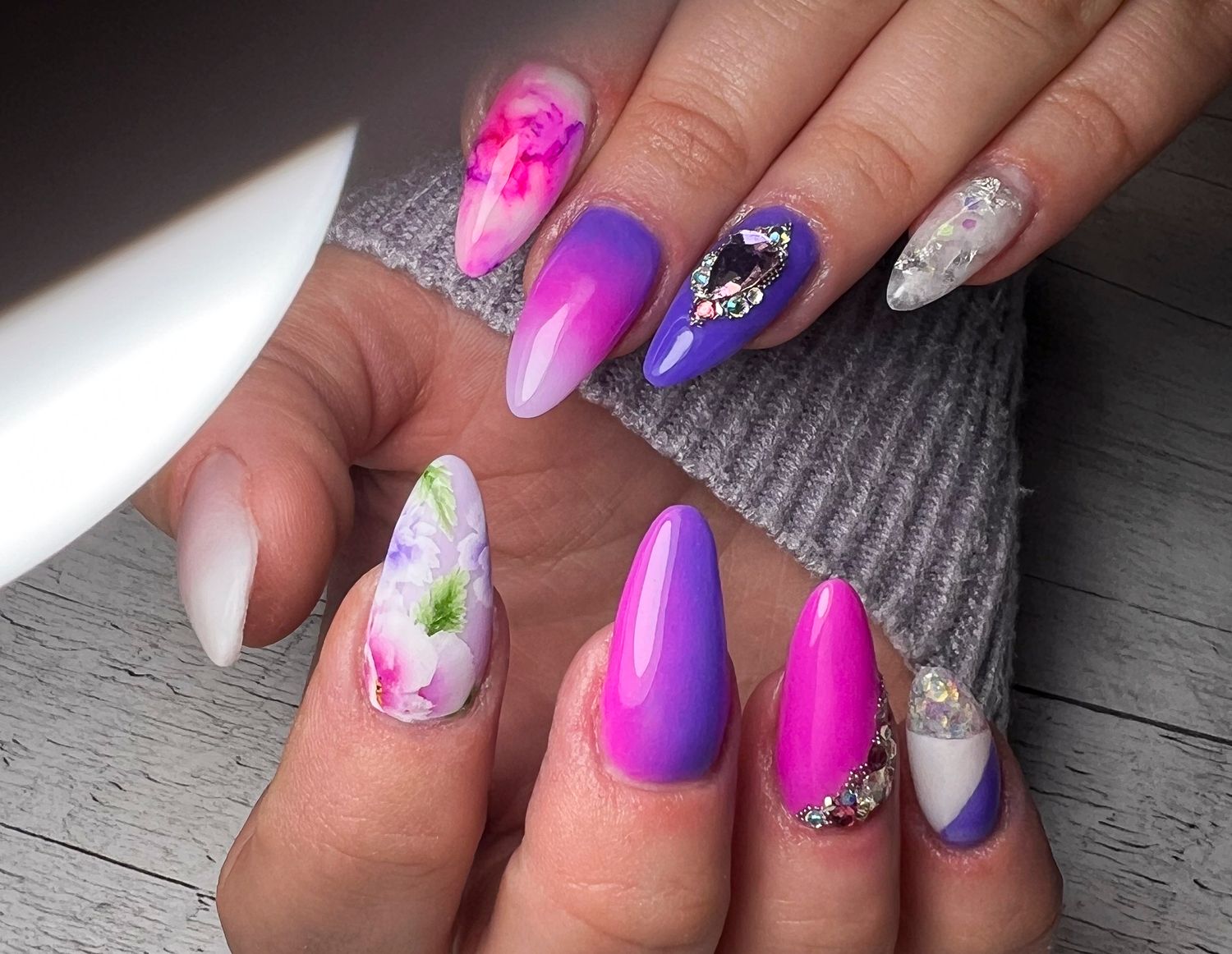 Beautiful nail art designs featuring purple ombre, pink gradients, sparkles, and floral accents on long acrylic nails.
