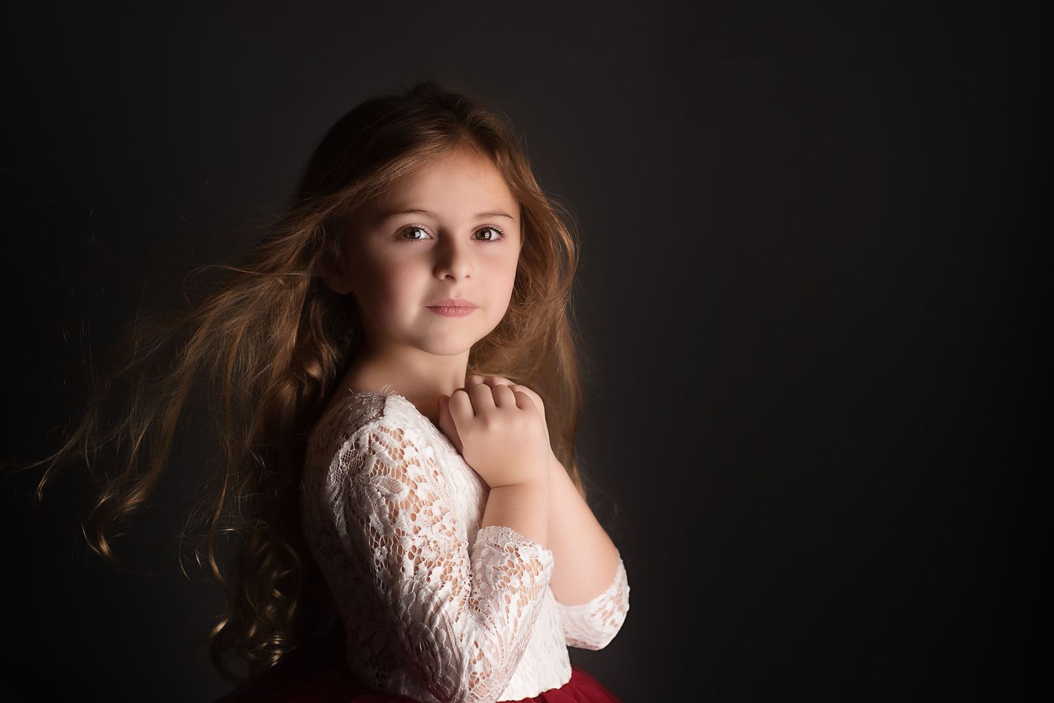 Seven artistic portrait photographs in low-light studio setting featuring dramatic lighting and red and white wardrobe.