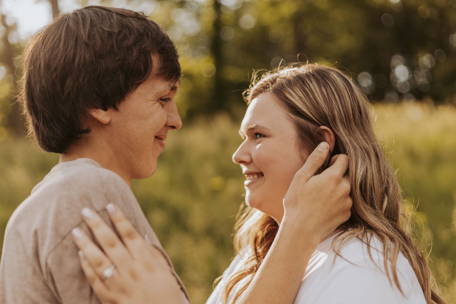 Romantic couple sharing an intimate moment outdoors in golden sunlight.