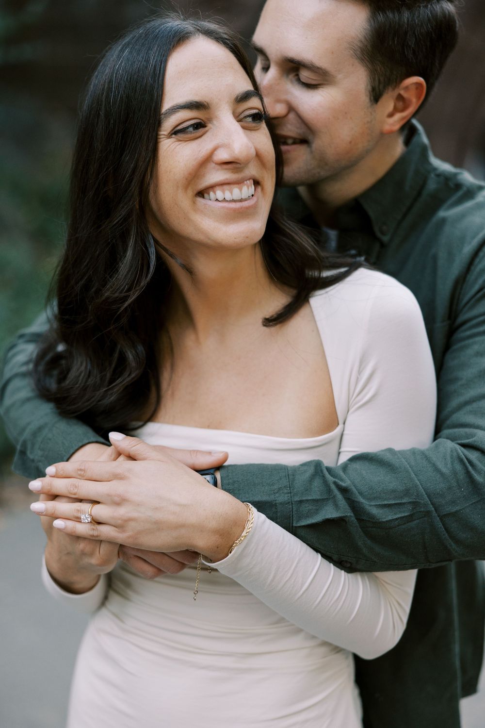 A romantic couple embraces while sharing a tender moment outdoors, showing genuine joy and connection.