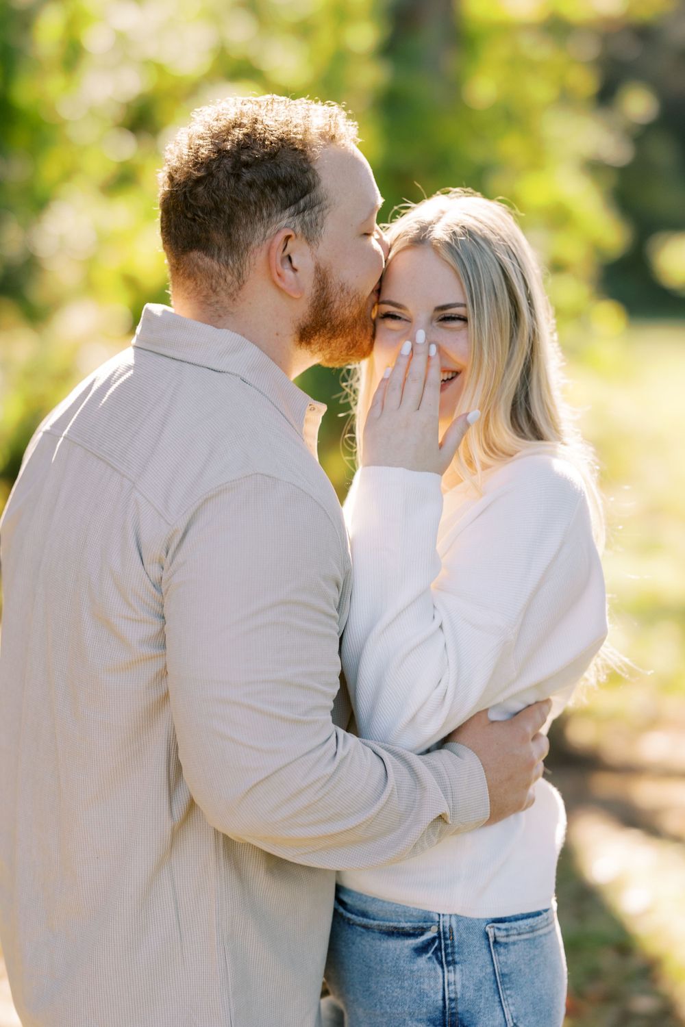 A joyful couple sharing a romantic moment outdoors in natural lighting.