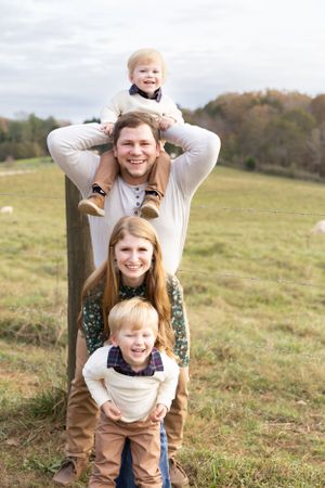 Playful family photos taken in an autumn field with piggyback rides and laughter.