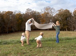 Action sequence of family playing and running together in a grassy autumn field.