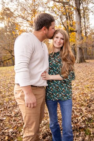 Candid autumn couple photos showing affectionate moments among fallen leaves.