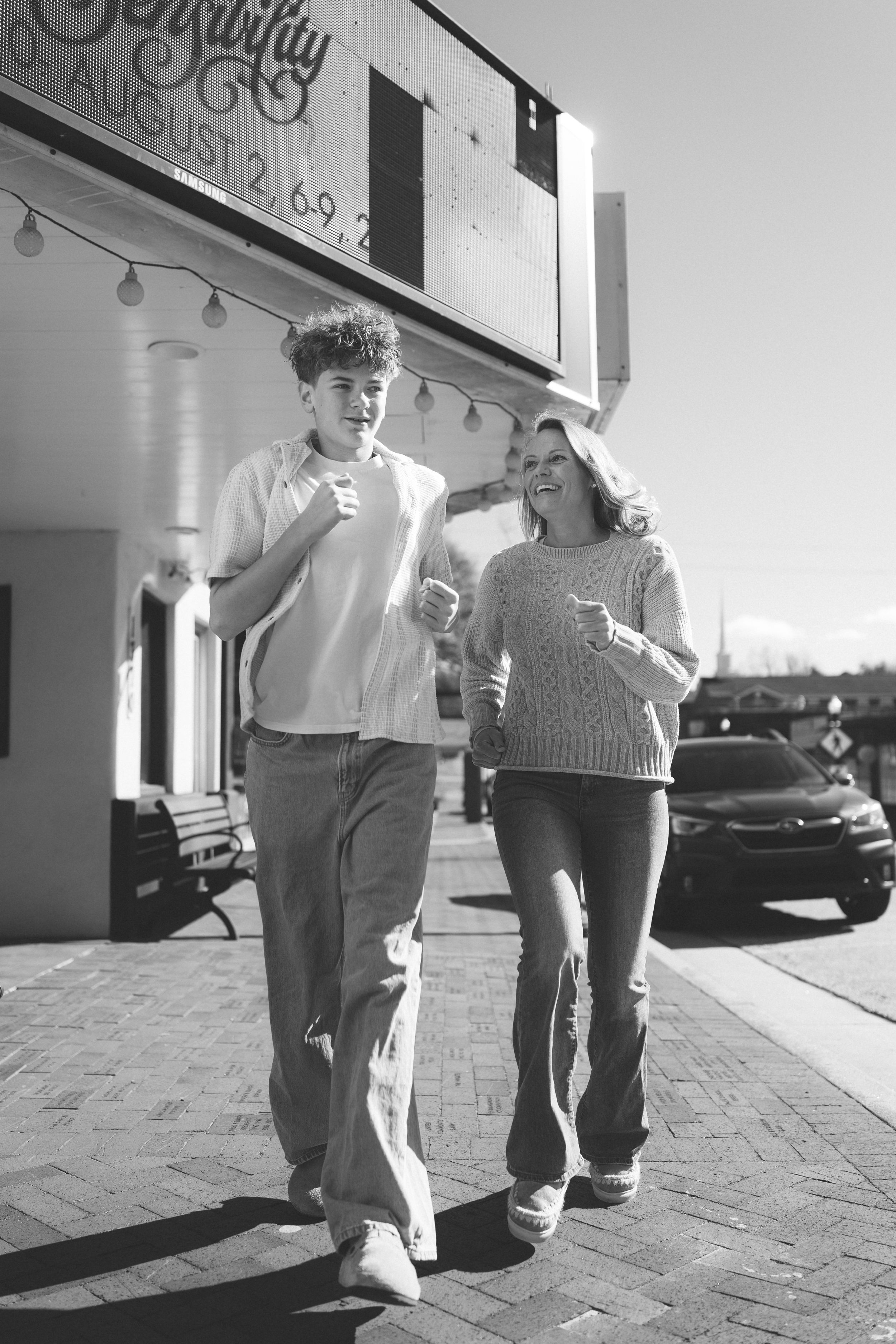 A series of low-angle black and white photos showing people's legs walking on a brick sidewalk.