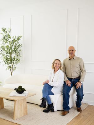 A series of five minimalist interior photos showing a white sofa and wooden table against a clean white wall.