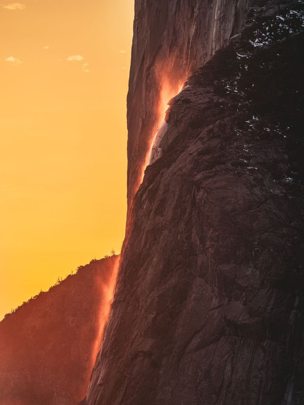 Sunset illuminates Yosemite's Horsetail Fall creating a glowing orange waterfall effect.