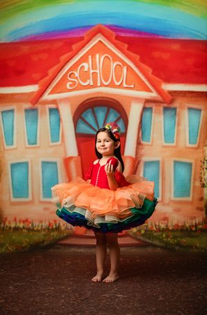 A colorful photo series against a painted school backdrop featuring a twirling dress and playful poses.