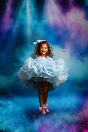 Dynamic portrait sequence showing white dress twirls in motion against dreamy blue and purple background lighting effects.