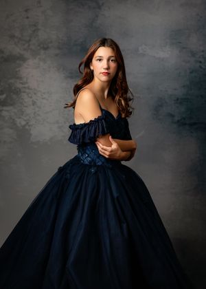 A ballgown photoshoot series showing five poses in a navy blue off-shoulder dress against a dark gray textured backdrop.