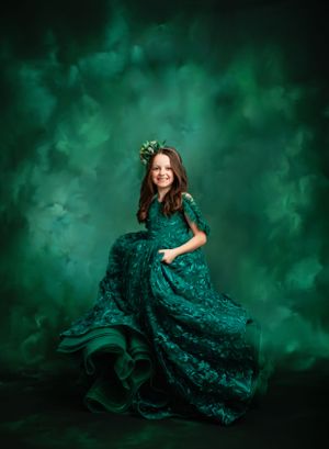 Ethereal portrait against emerald green misty background with dramatic lighting.