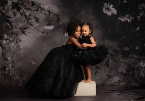 Multiple artistic photos of women in black dresses against a dark dramatic backdrop.