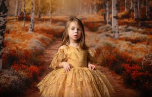 Autumn forest scene featuring golden dress against orange foliage.