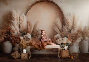 Cozy boho nursery setup with pampas grass, neutral decor, vases and baskets against a beige backdrop.