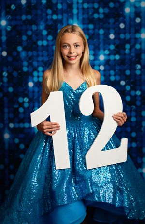 A sequence of four photos showing someone in a sparkly blue dress holding up numbers against a glittering blue background.