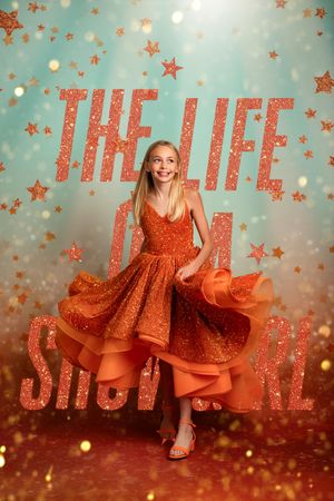 Sparkly holiday photo series with orange dress twirling against teal backdrop with glowing stars and text decoration.