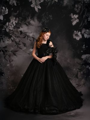 A dramatic black tulle ballgown photographed in moody lighting against a dark floral backdrop with multiple dress angles shown.