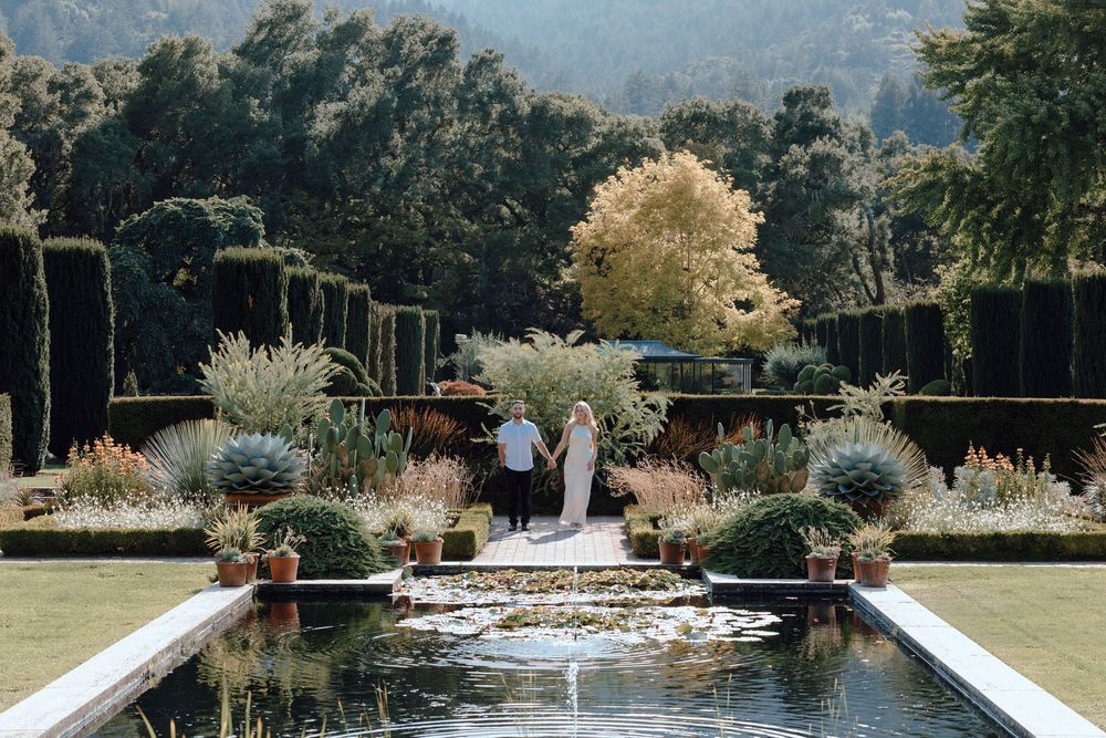A tranquil water feature with stone walls and landscaped gardens creates a serene outdoor setting in a park.