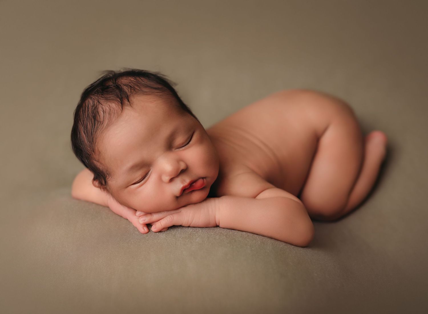 Baby newborn boy posed and sleeping on a green blanket. 

Best Newborn photographer, Peoria, il.