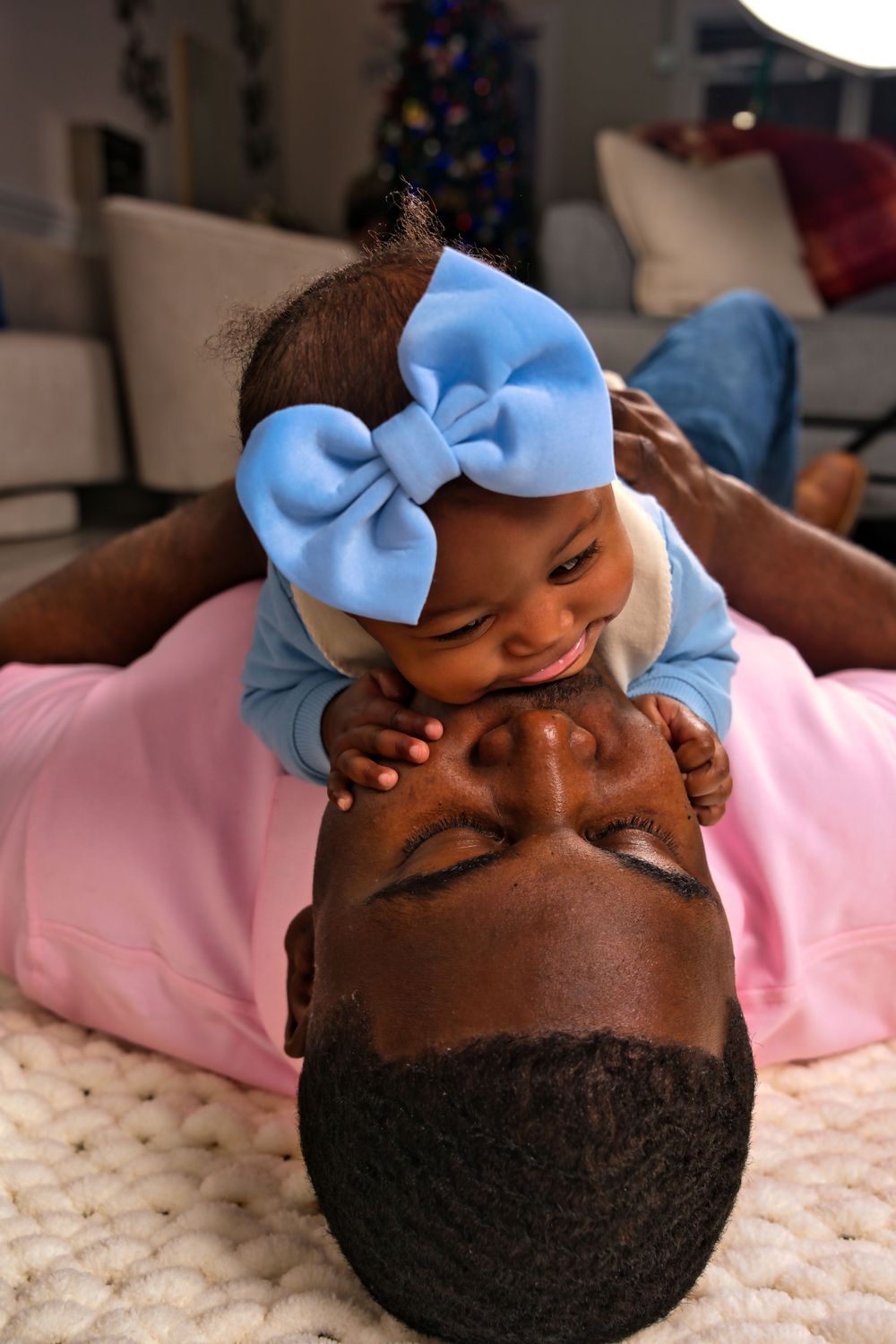 Series of close-up shots showing a sleeping baby wearing a light blue bow on a pink blanket.
