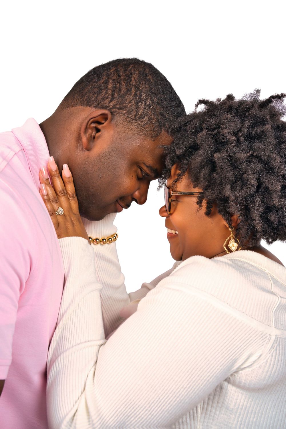 A tender moment captured in profile as two people share an intimate embrace against a light background.