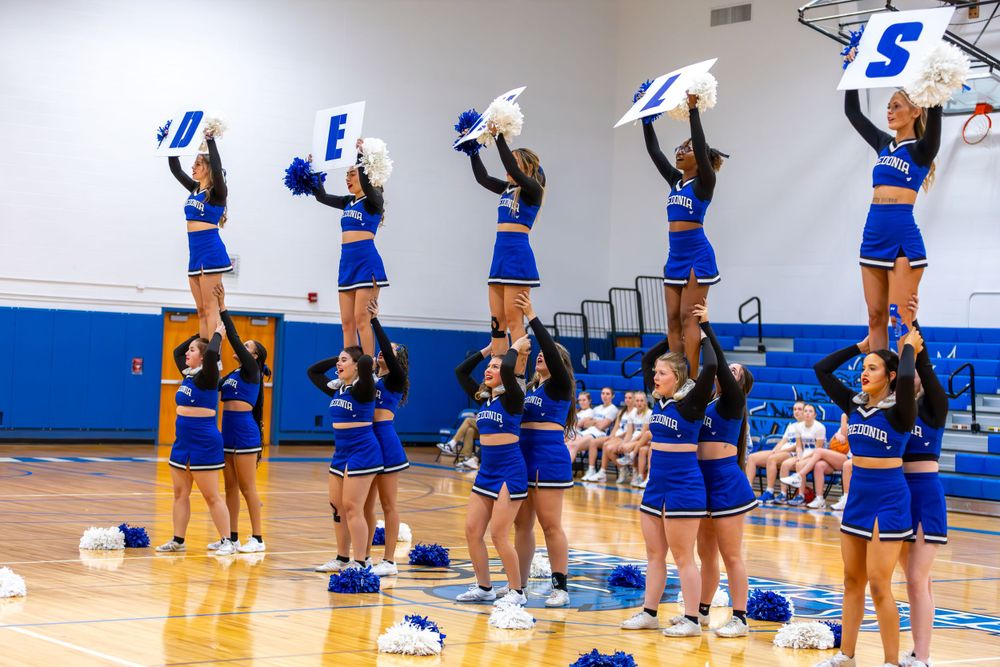 Cheerleaders executing synchronized formations on a gymnasium floor.