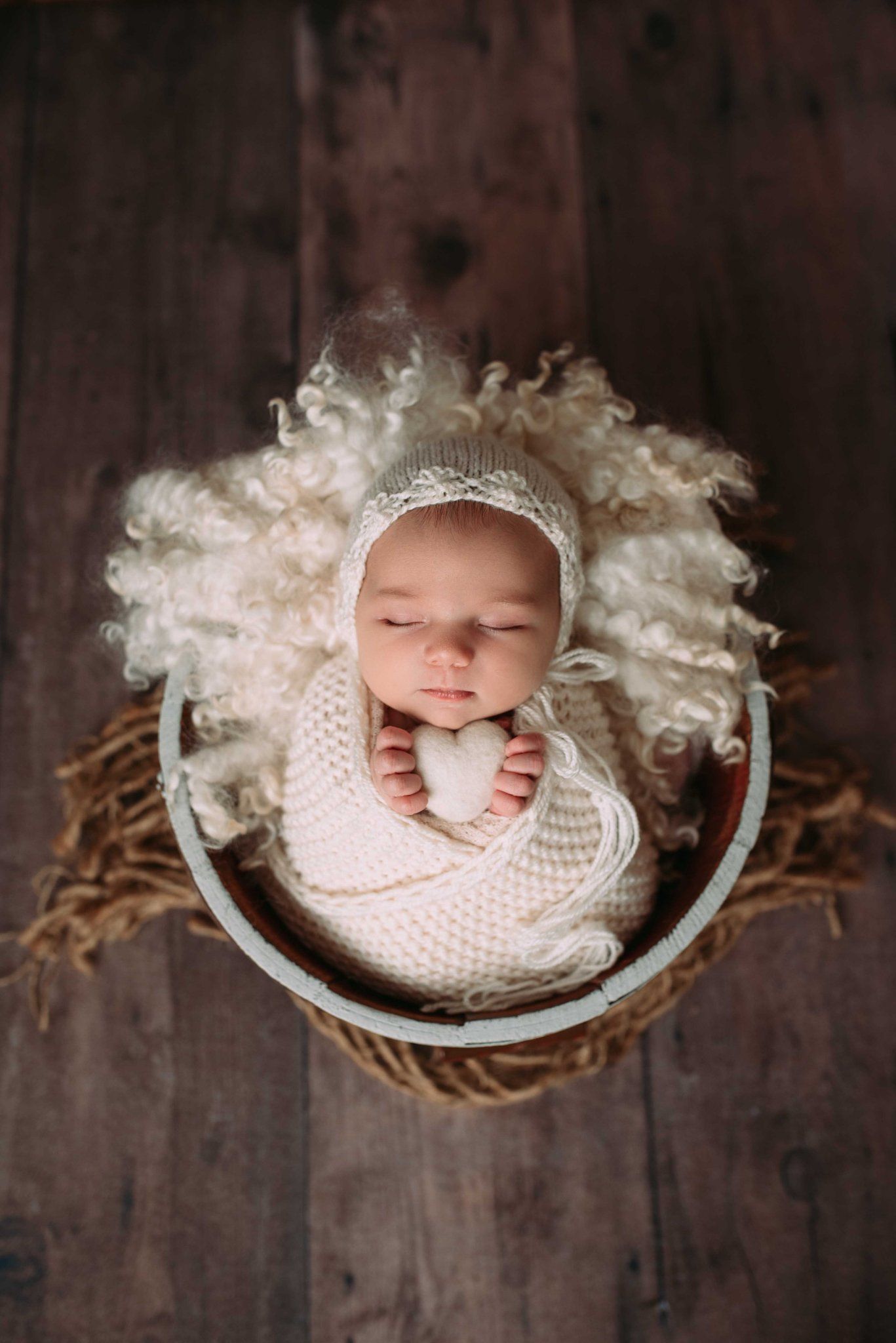 Sleeping newborn surrounded by boutique props in cozy photography studio near the Twin Cities