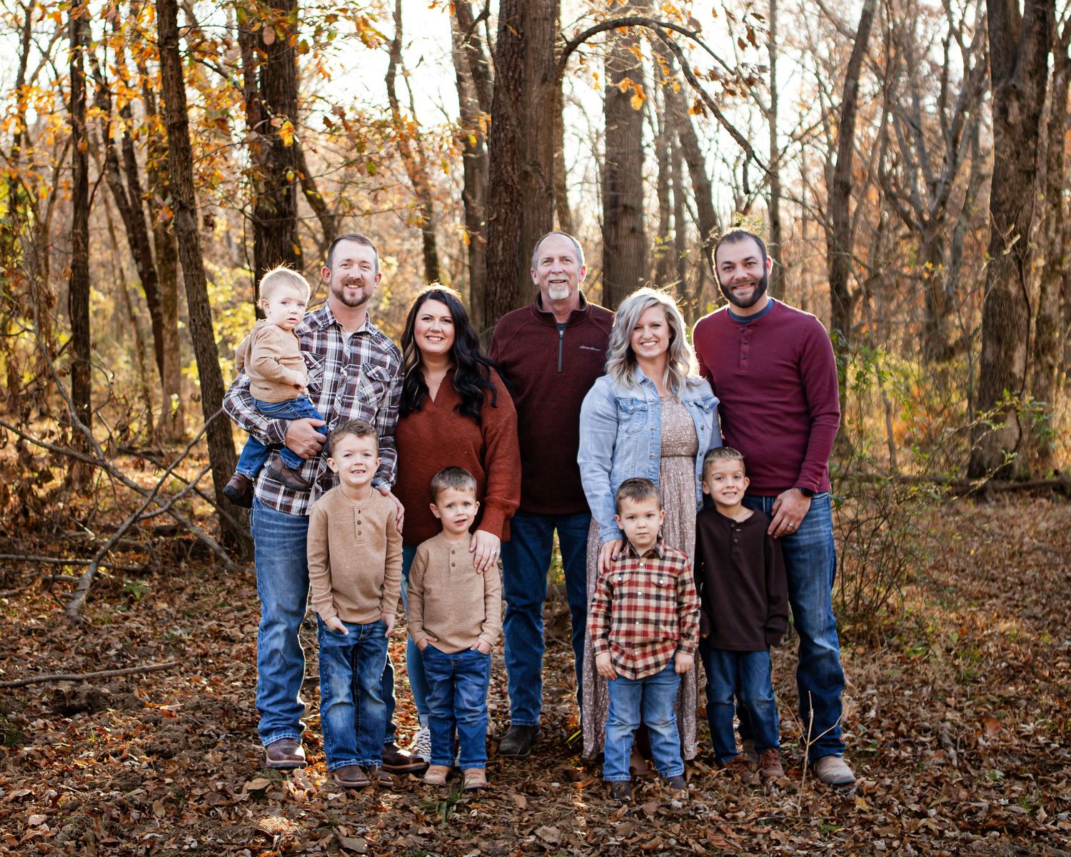 Family group photos taken in an autumn forest setting with fallen leaves and trees.