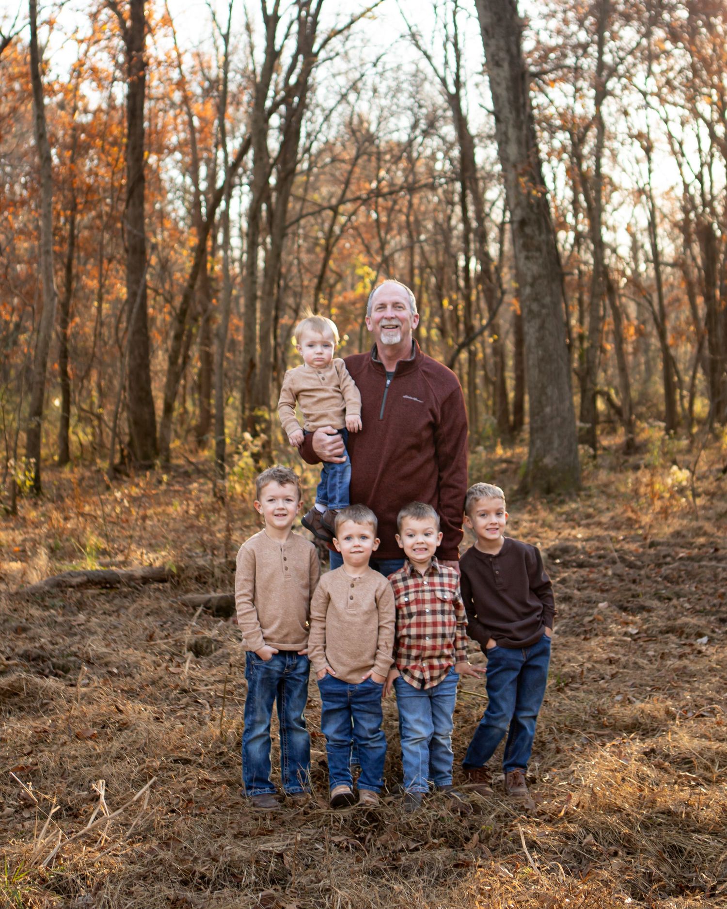 Family group portrait of father with five children in autumn woods setting.
