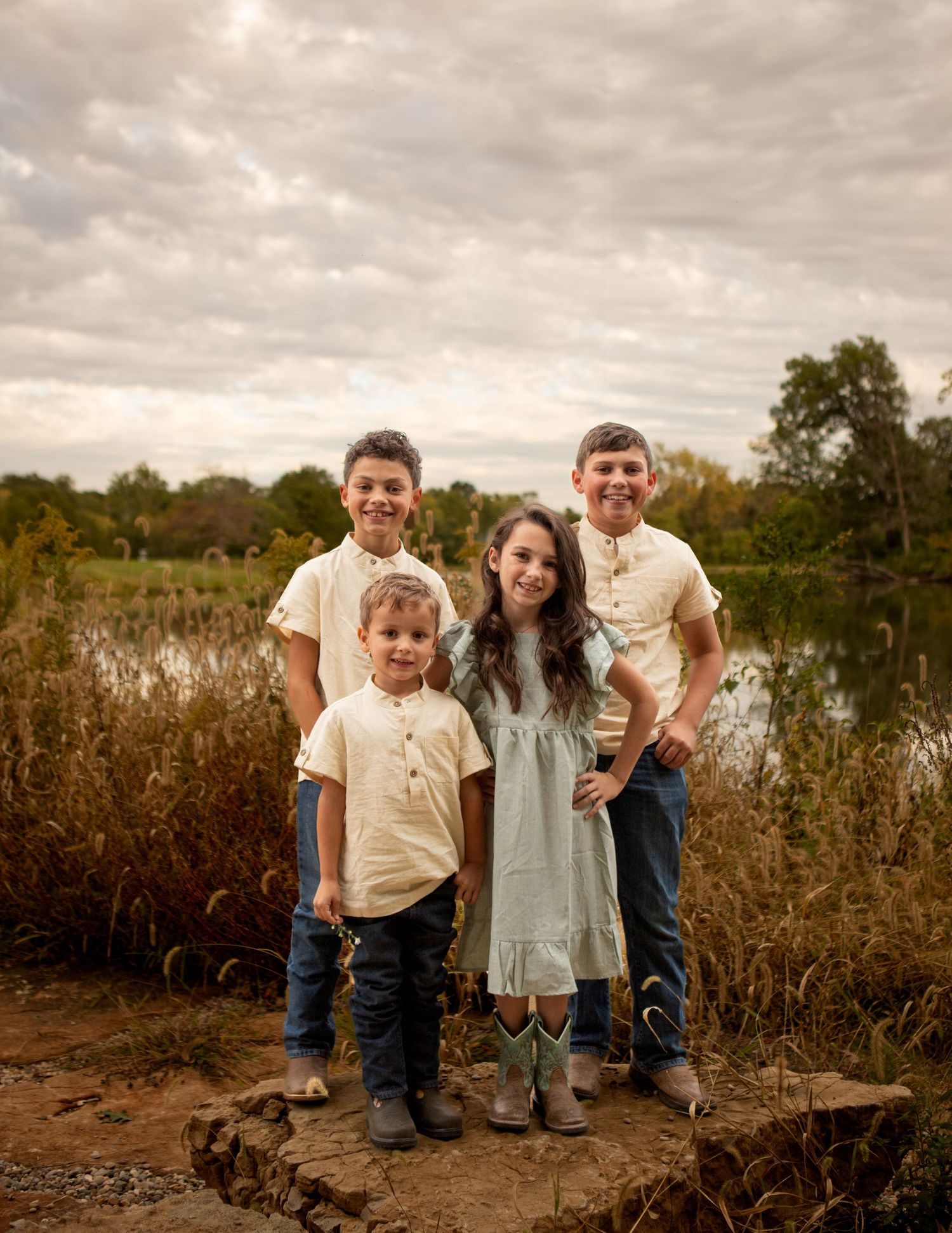 A family poses together near a lake during golden hour.