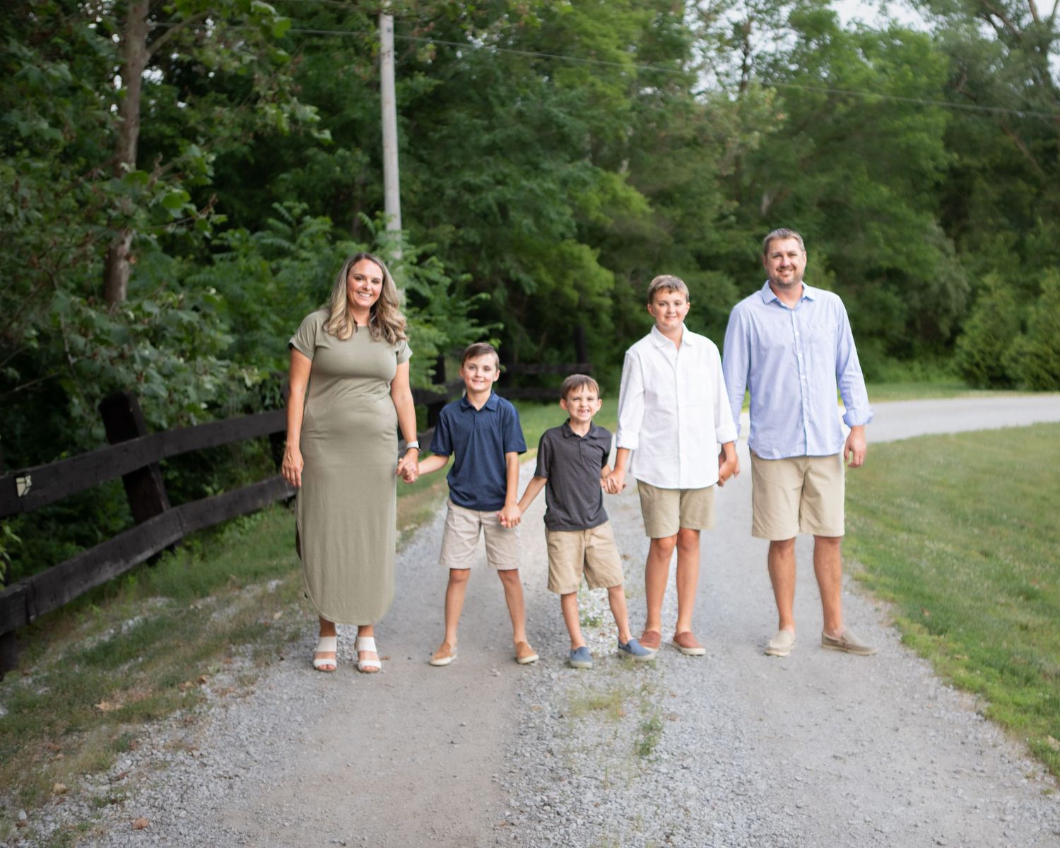 Group walking together on a gravel path through a green park setting.