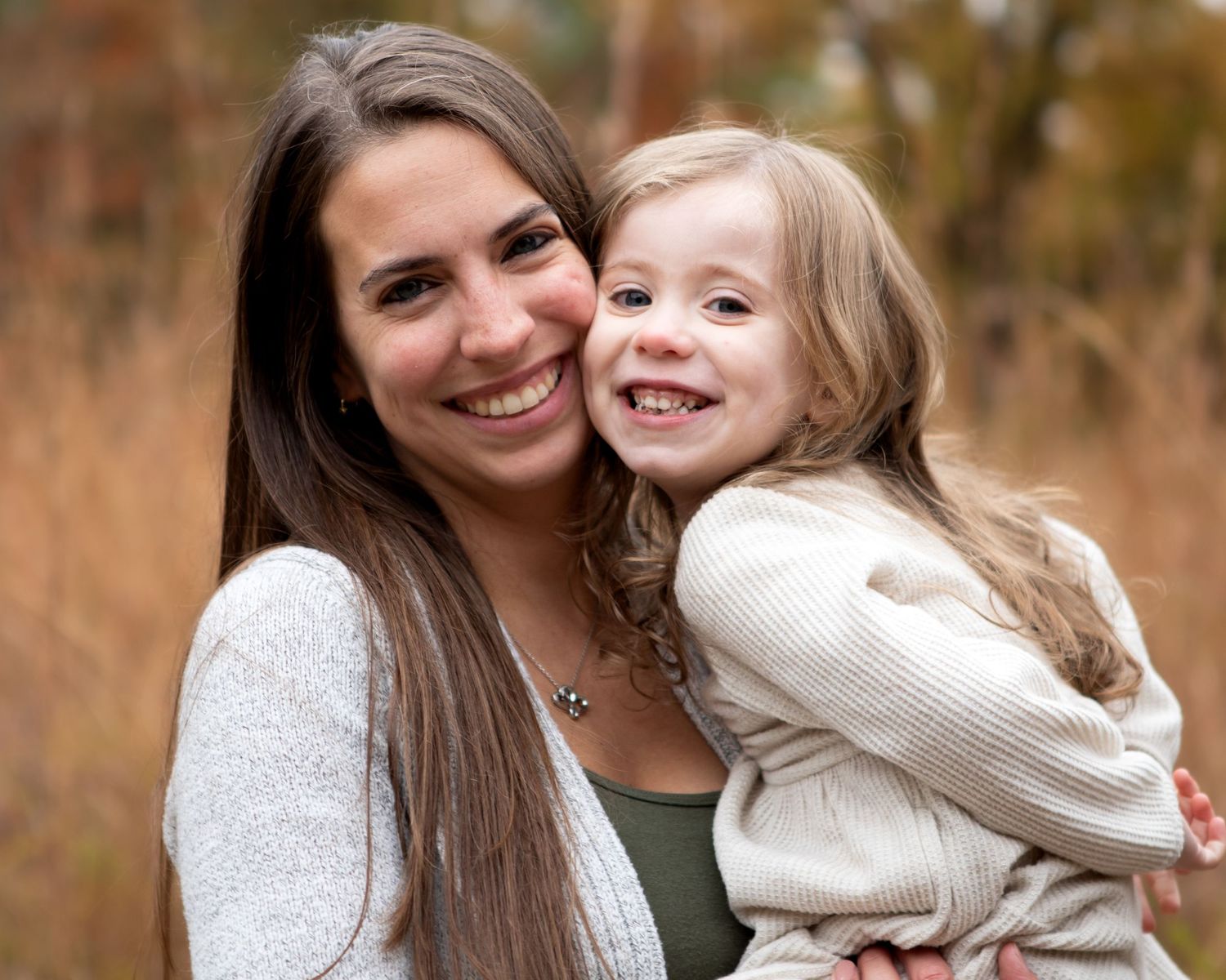 Mother and daughter share tender moment in casual outdoor portrait session.
