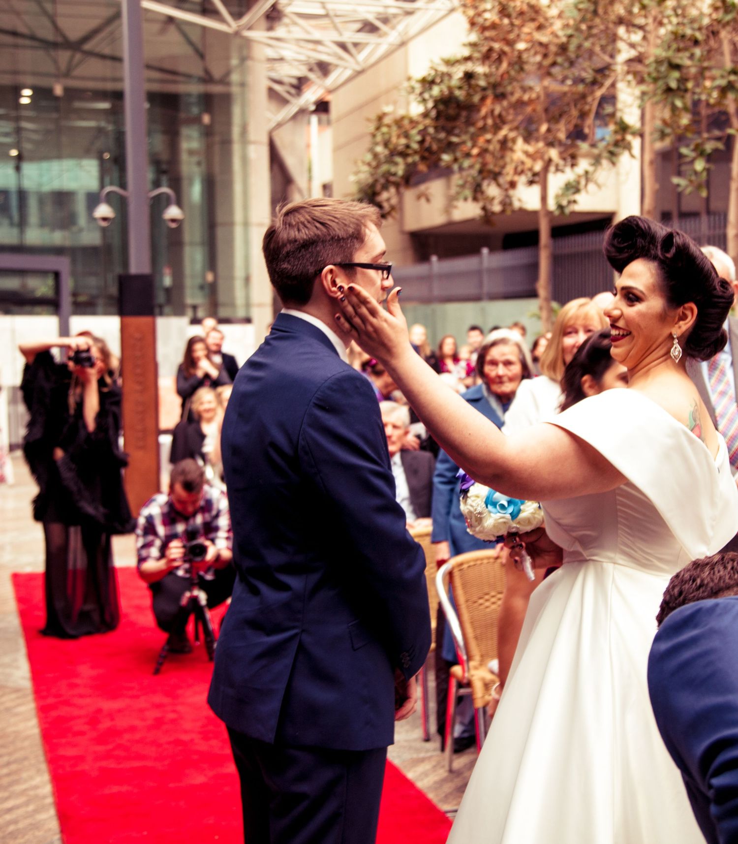 Playful moment at outdoor celebration with white dress and formal attire.