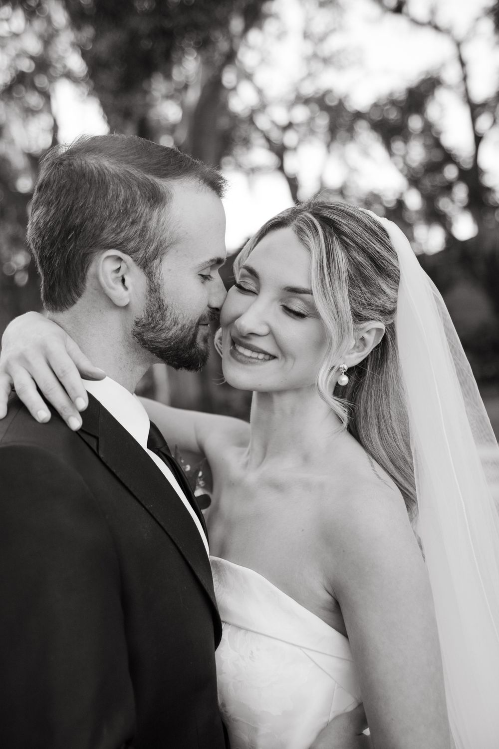 Intimate black and white portrait of newlyweds sharing a tender moment.