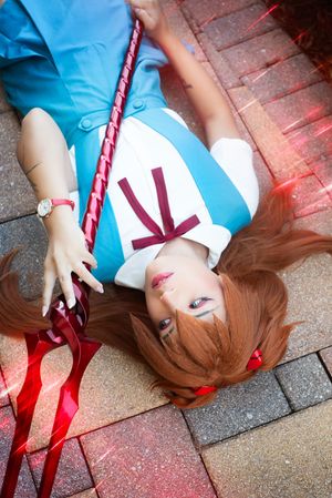 Cosplay character at Holiday Matsuri portrait interacting with camera, dynamic pose with staff prop