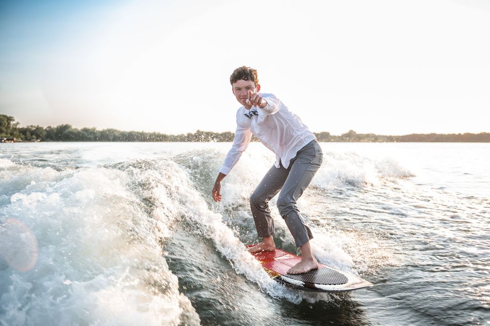 Action shot of wakesurfing behind boat on sunny day.