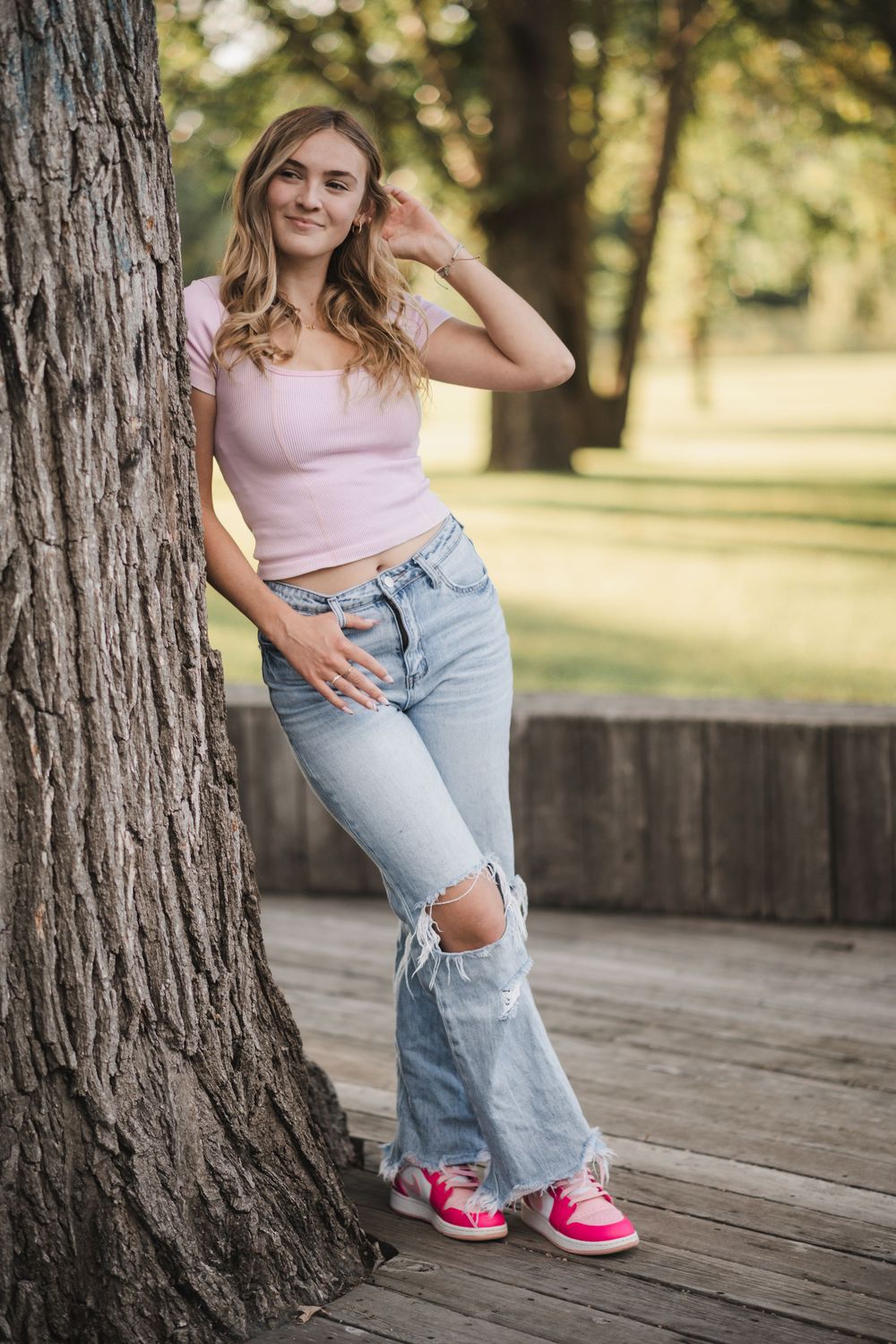 A series of casual lifestyle photos on a wooden deck featuring light pink top, distressed jeans, and bright pink sneakers.