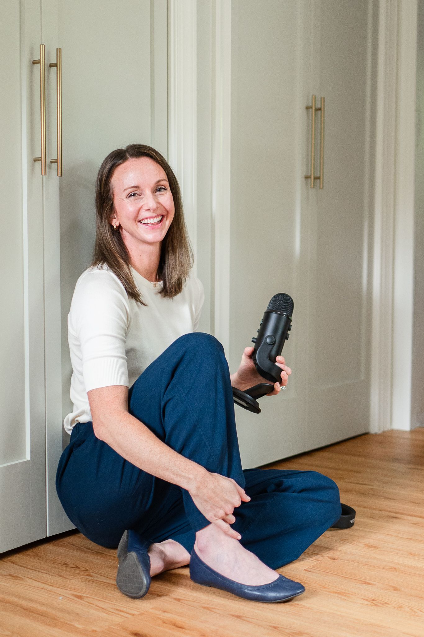 Podcast host holds her microphone in a headshot during her personal brand session.