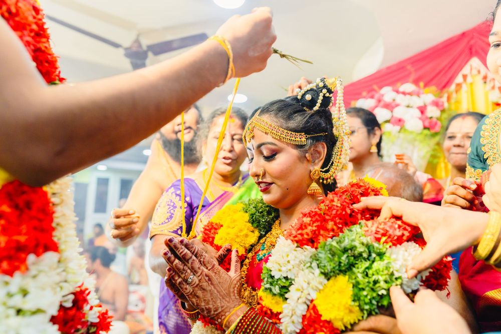 Traditional pre-wedding ceremony with yellow and red flower garlands and ceremonial decorations.