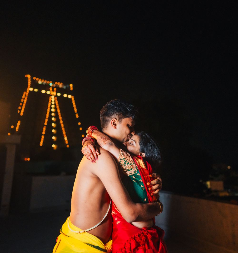 Intimate wedding couple portrait with city lights glowing in background at night.