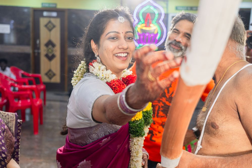 Traditional Indian ceremony participant applying vermillion during a festive ritual.