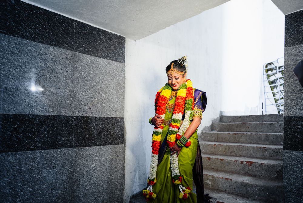 Traditional South Indian wedding attire with colorful garlands in modern setting.