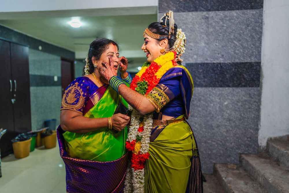 Emotional moment during traditional Indian wedding ceremony with colorful silk sarees.