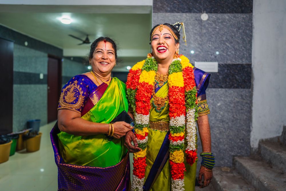 Joyful celebration in traditional South Indian wedding attire with bright flower garlands.