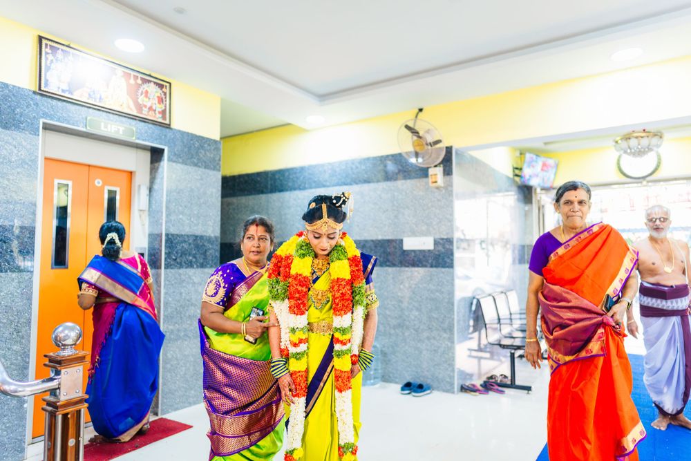 Traditional Indian wedding gathering in a modern hallway with yellow and grey walls.