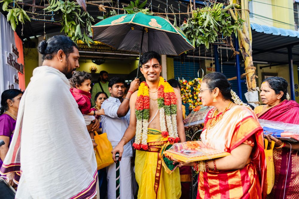 Traditional Indian wedding ceremony with people gathered around wearing colorful attire and garlands.
