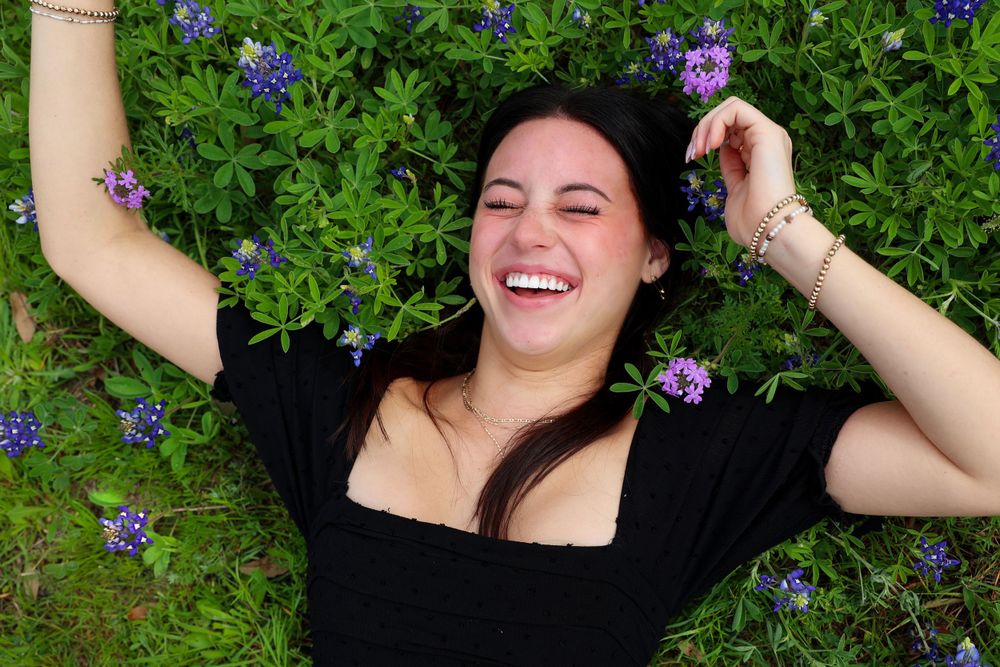A joyful moment captured lying in a field of purple wildflowers.