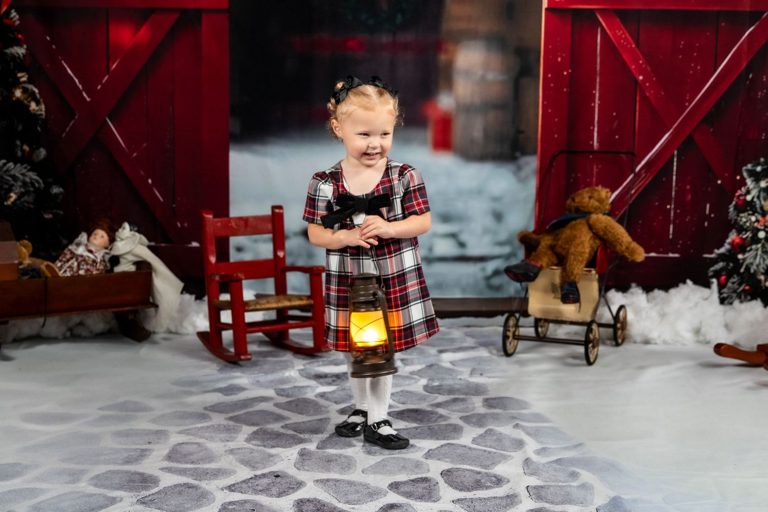 a little girl with pigtails in plaid holding a lantern